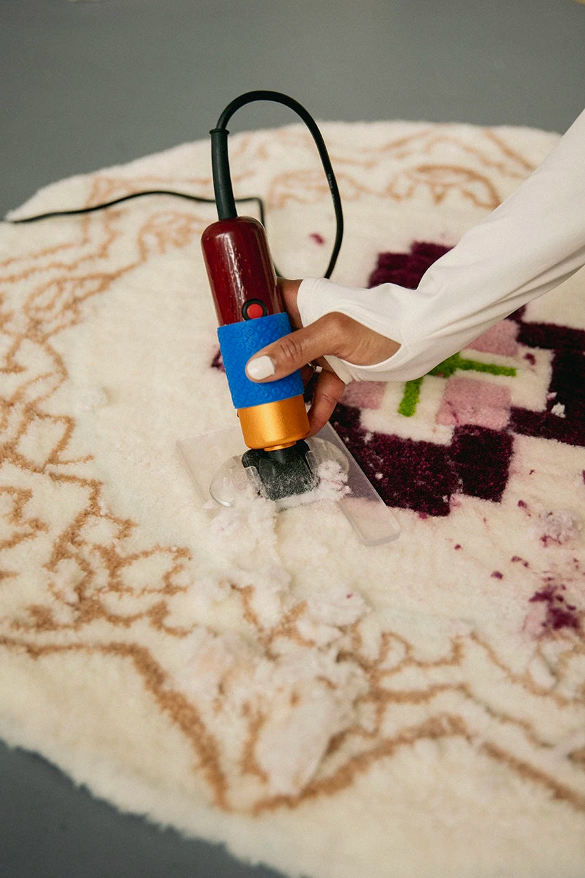 Detalle del proceso de esquilado y nivelado de una alfombra artesanal con máquina recortadora durante un curso de tufting de Jugo.