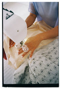 Primer plano de una mujer utilizando una máquina de coser profesional en el taller de confección de Jugo, trabajando en una pieza textil.